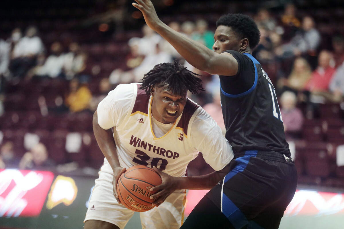 Winthrop’s D.J. Burns Jr. heads to the basket around Asheville’s B.J. Marable Thursday as the Eagles take on the UNC Bulldogs in Rock Hill.