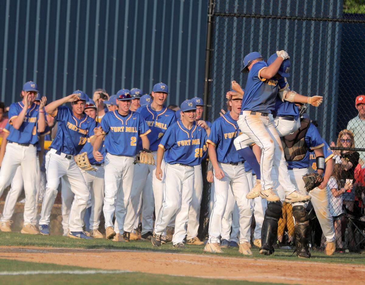 The Fort Mill High School baseball team celebrates after scoring two runs.