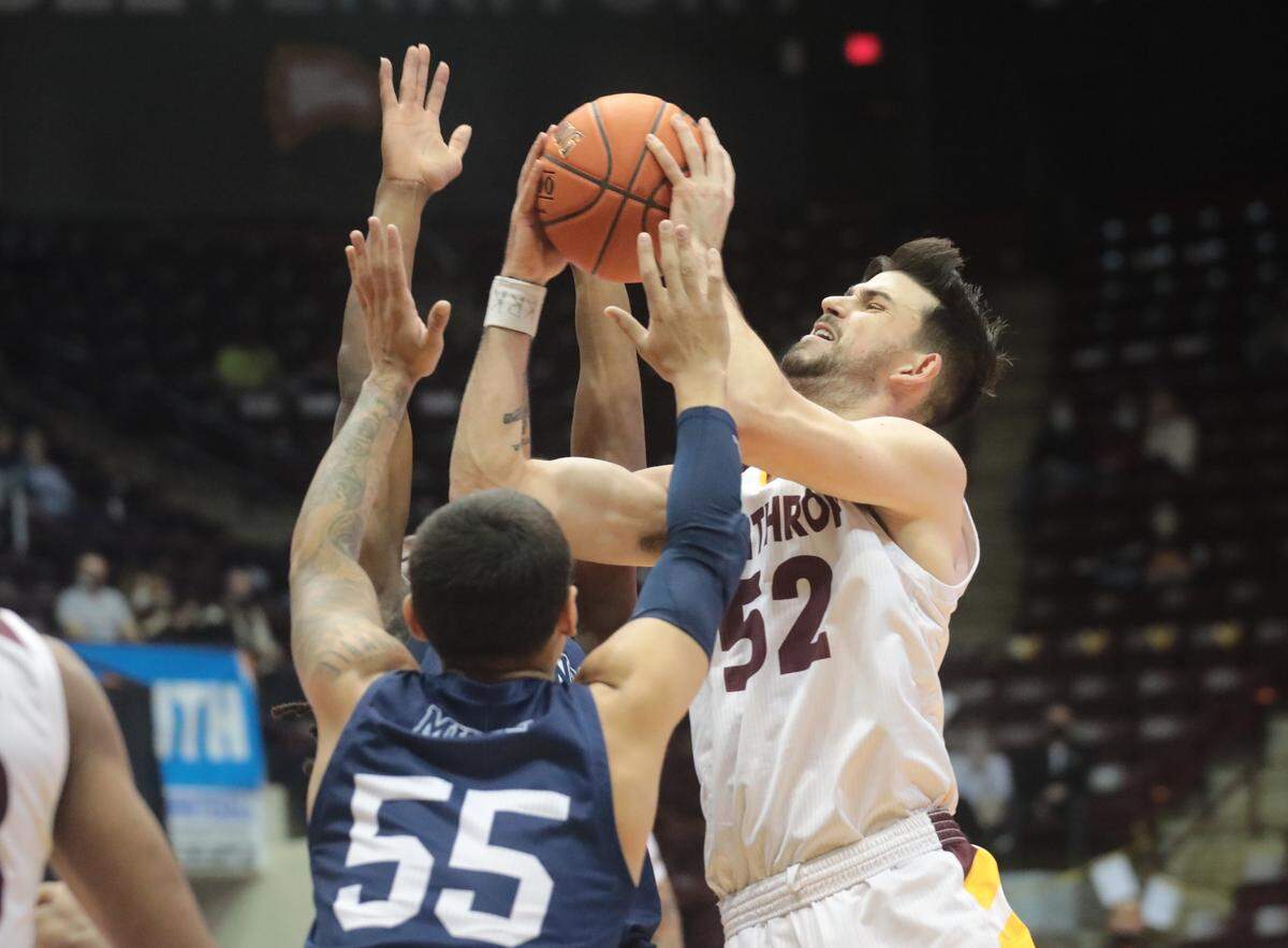 Winthrop’s Chandler Vaudrin heads to the basketball as Longwood’s Juan Munoz tries to block him.