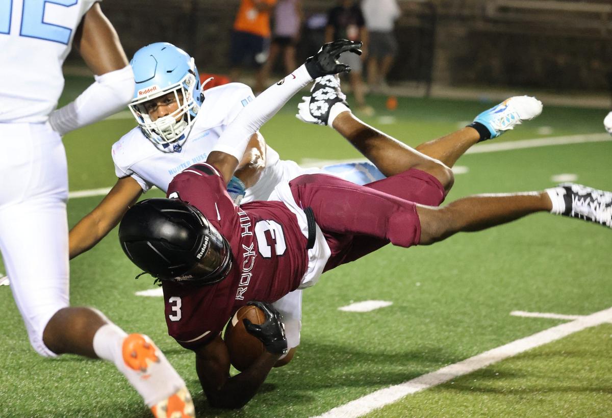 Rock Hill’s Malik Clark falls next to Hunter Huss’s Moises Pena Friday at the WRHI Football City USA scrimmage in Rock Hill.